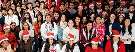 Cyntexa employees gathered for a celebration, several wearing red Santa hats
