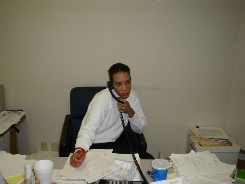 Cynthia Stewart working on the telephone at a paper-covered desk during Power Personnel's first year