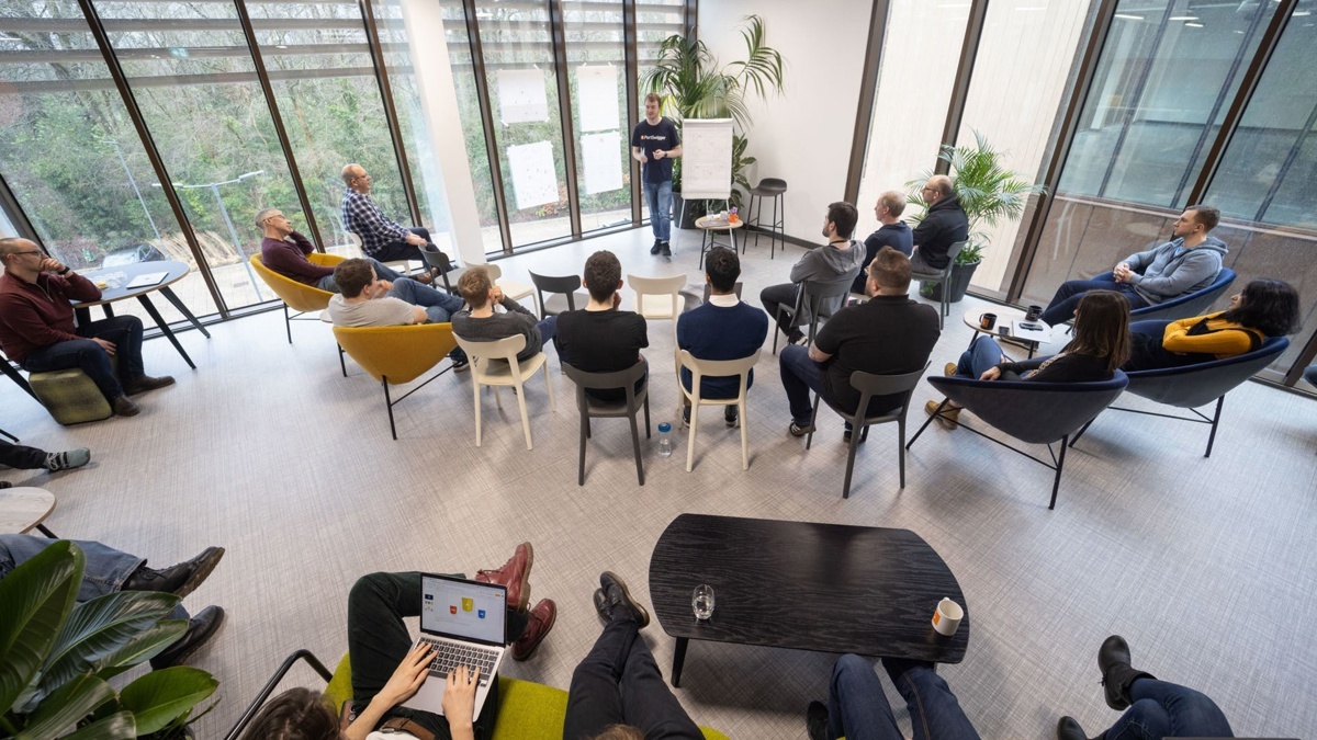PortSwigger colleagues seated in a circle during a session in a bright office