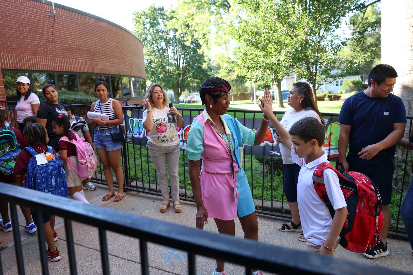 Freda Mallett welcomes children with high fives at Steuben Elementary School in Kankakee