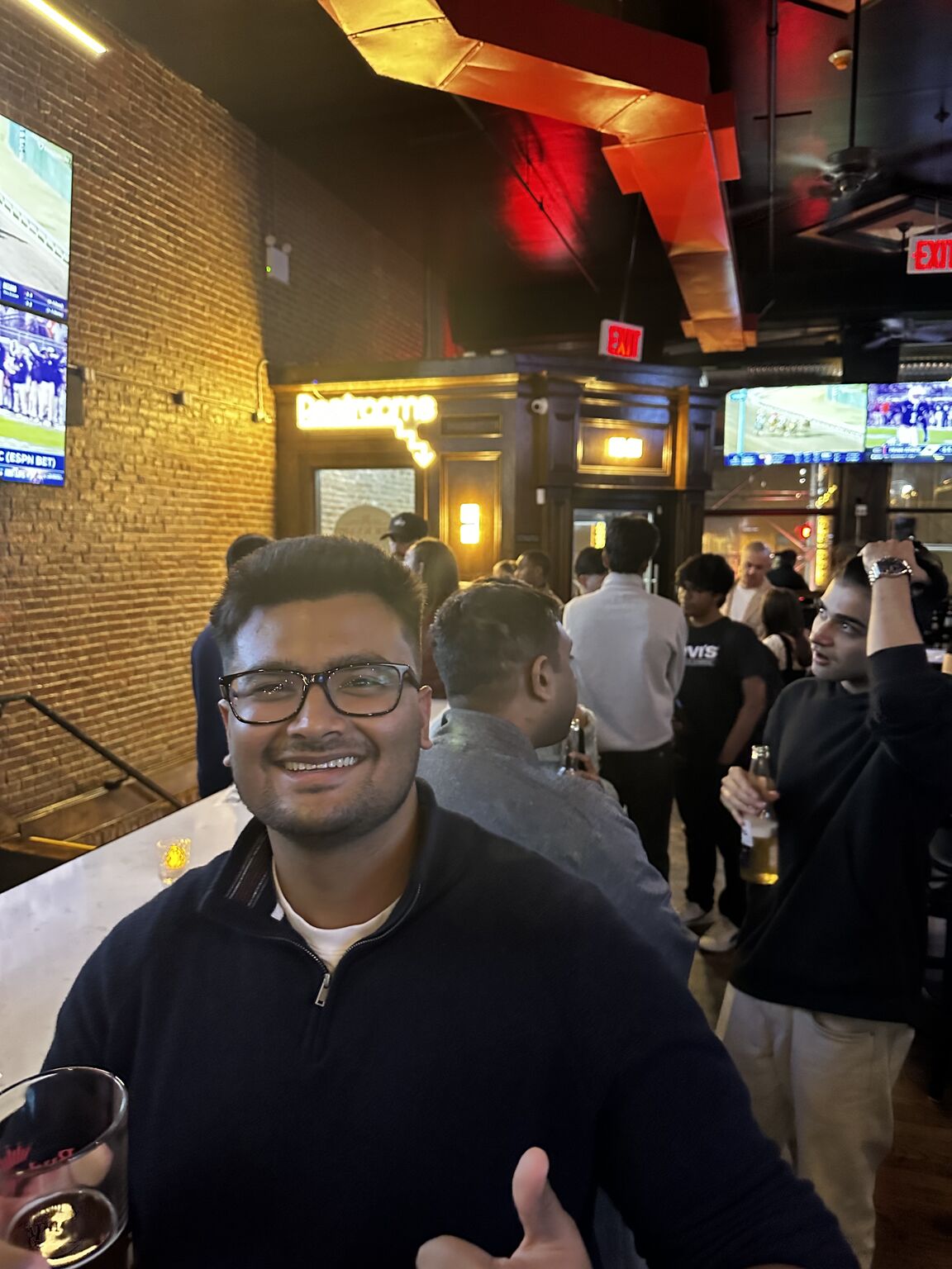 Daivik Goel smiling at a crowded Founders Brew event in New York