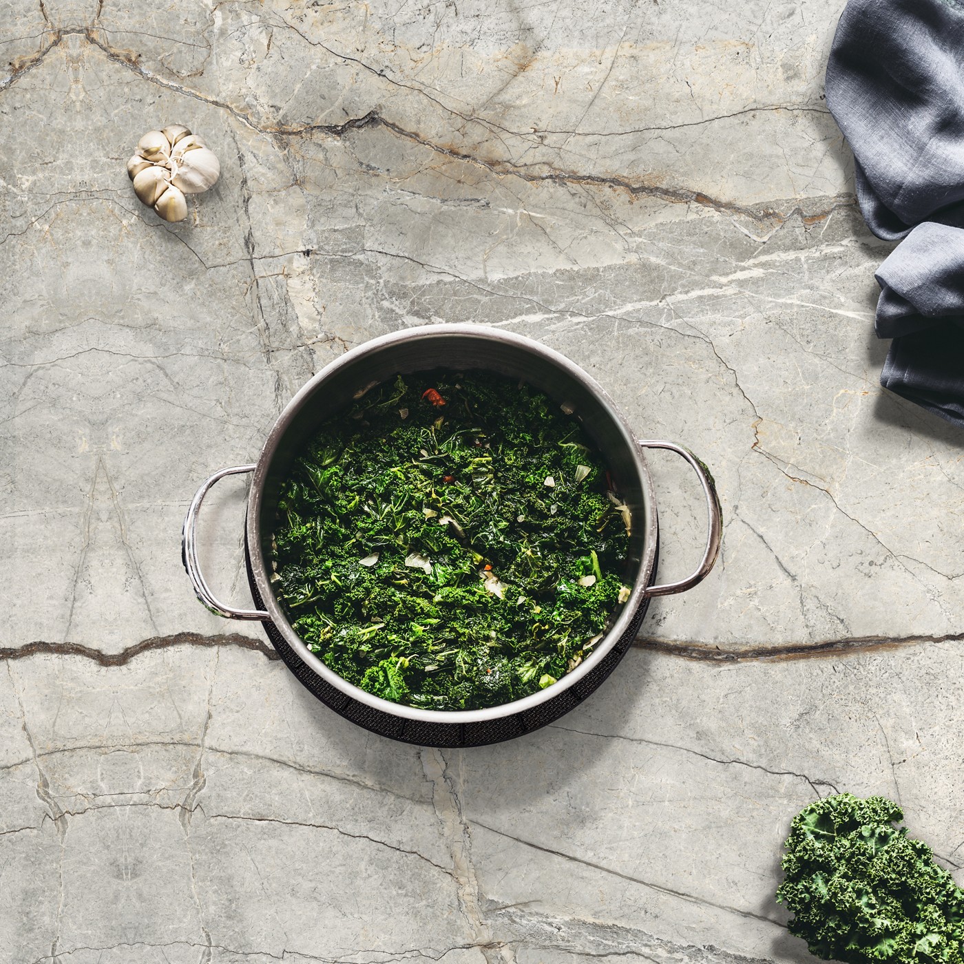 Marble-look Panoramic Elestial porcelain countertop with a pot of greens
