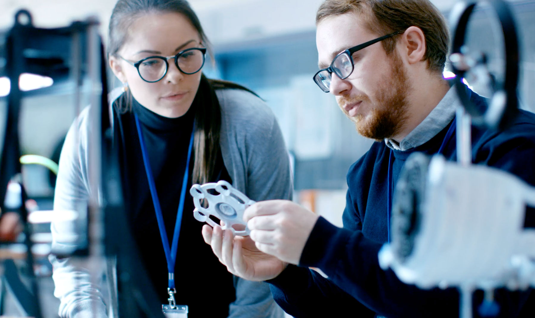 Two participants examine a physical component inside the ideaHUB