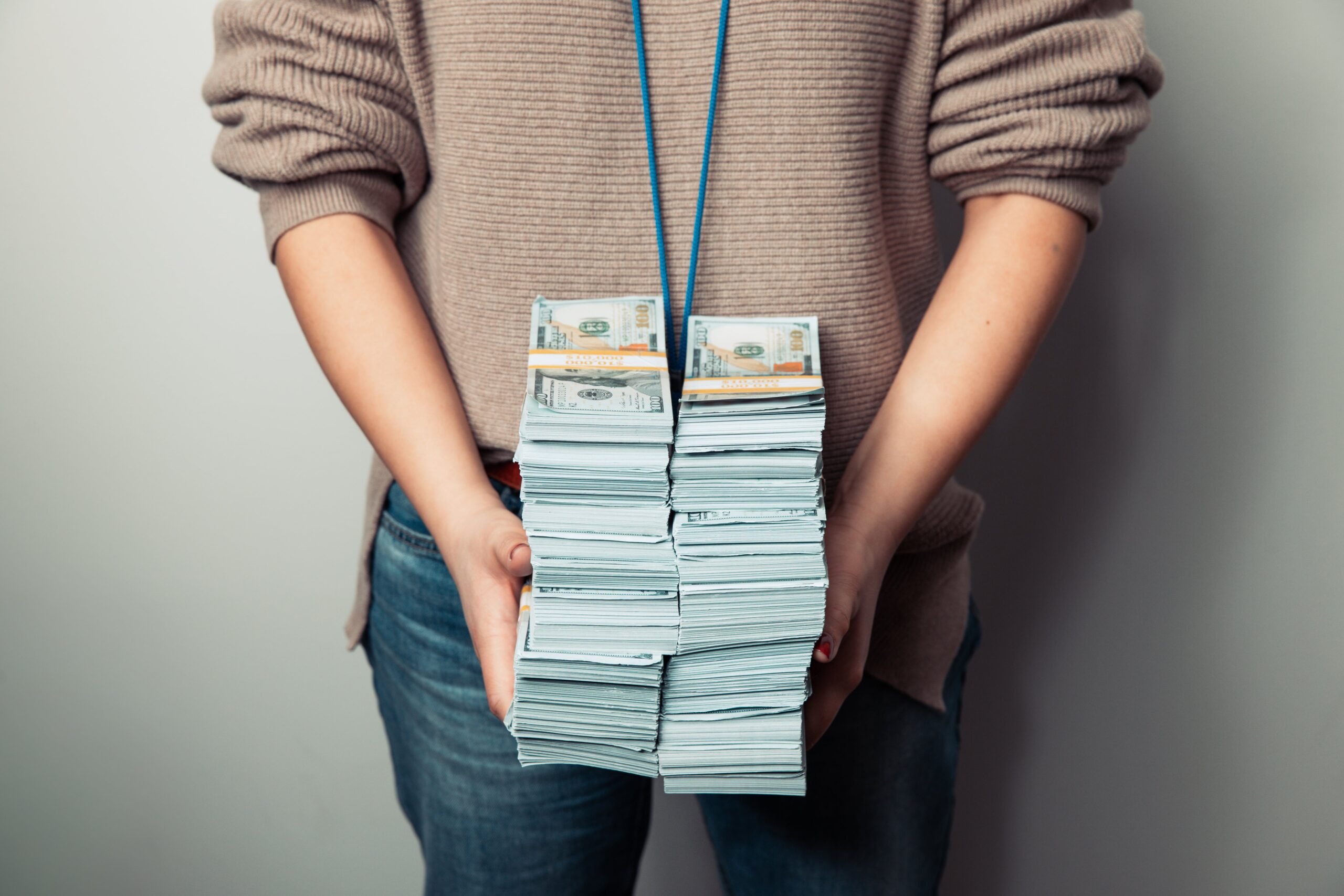 Person holding bundled cash, illustrating the physical handling involved in cash-heavy businesses