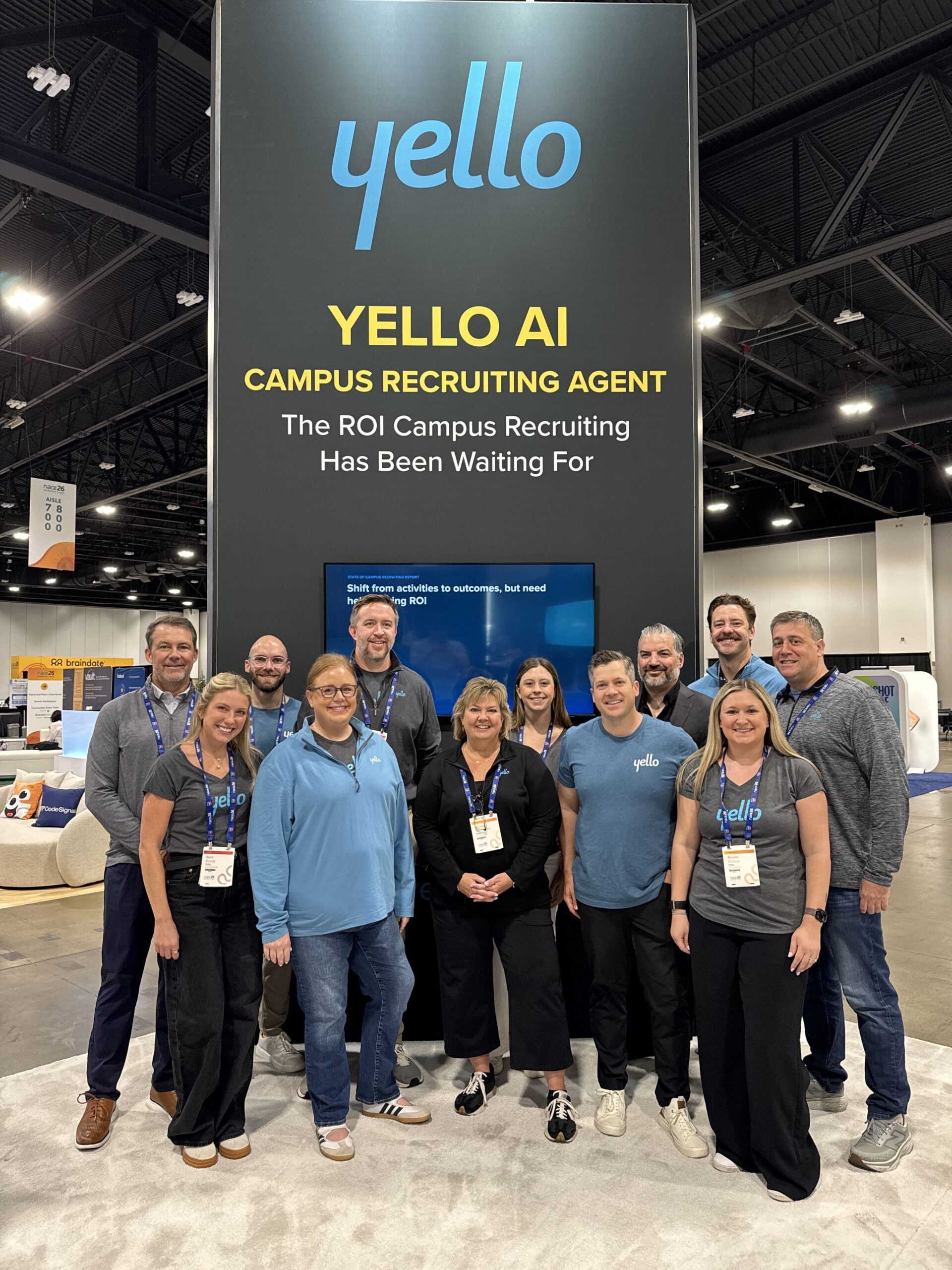 Yello team gathered at its NACE26 exhibition booth beneath a Campus Recruiting Agent sign