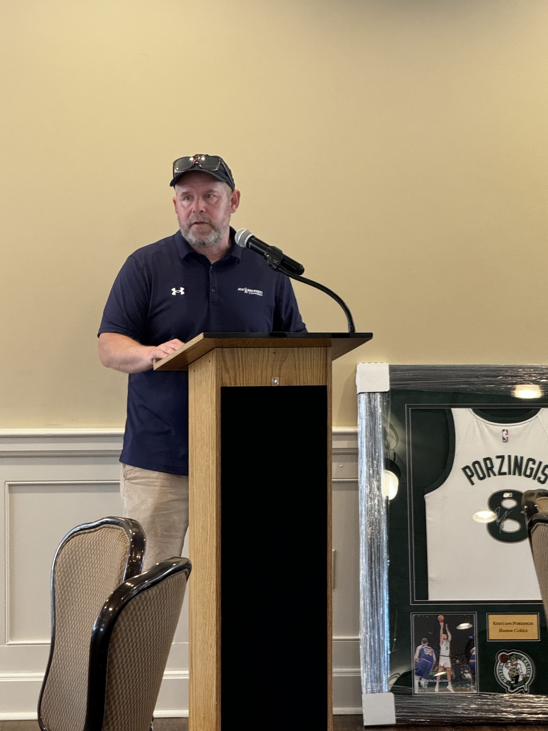 Dan Gill at a lectern addressing guests at an Amplix golf fundraiser