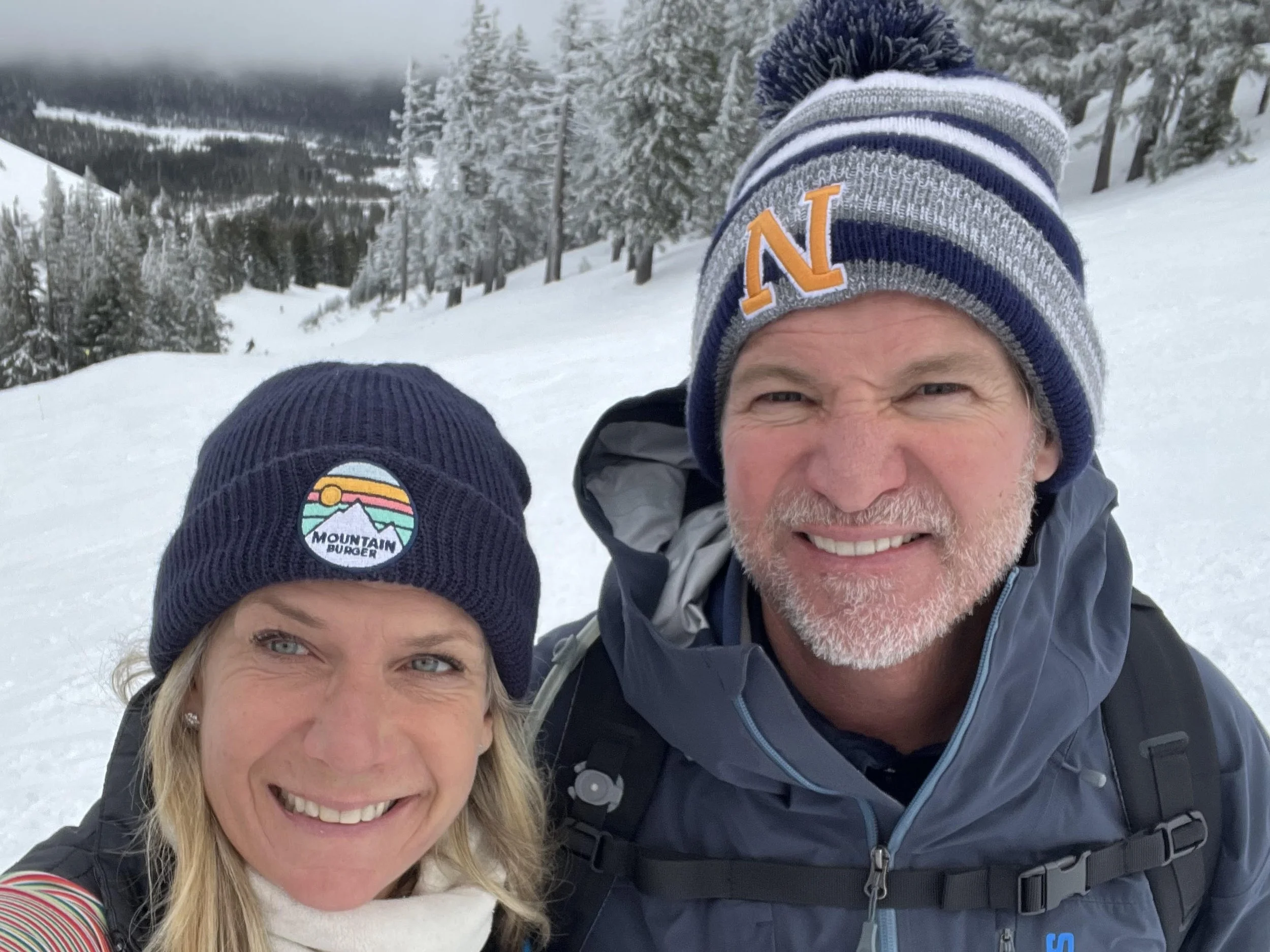 Dan Hobin, at right, smiling with a companion in a snowy mountain landscape.
