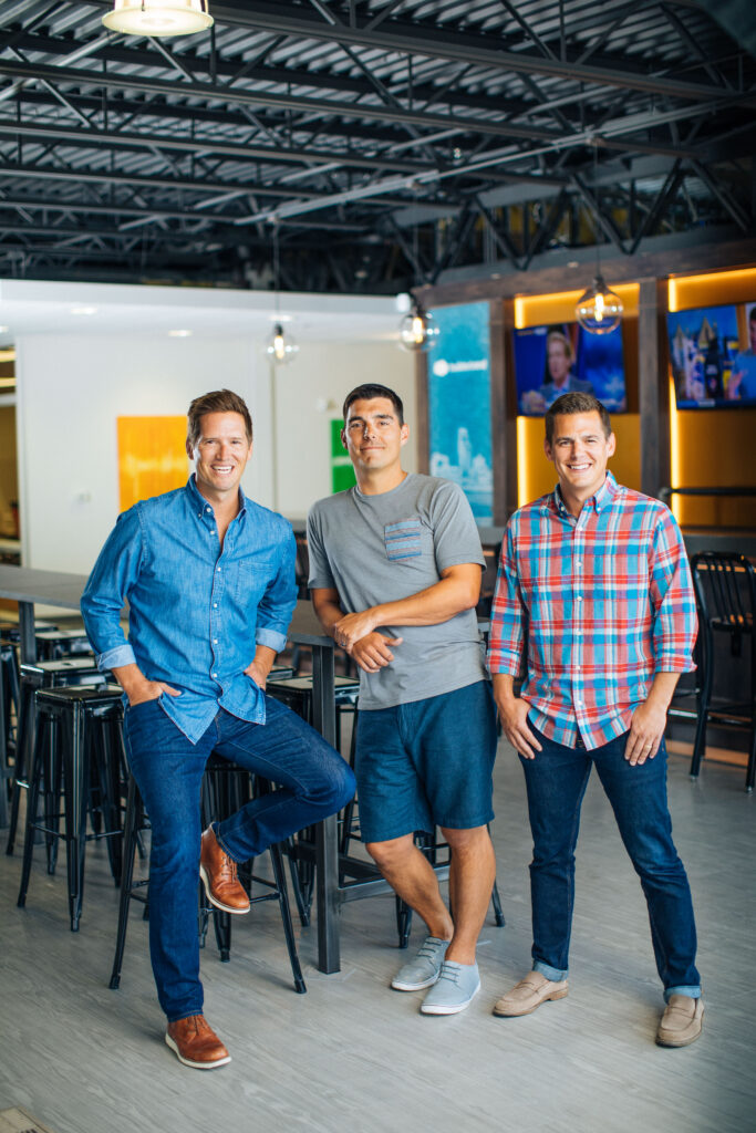 Dan Houghton, Jeff Dugger and Steve Dugger standing together in a communal office space