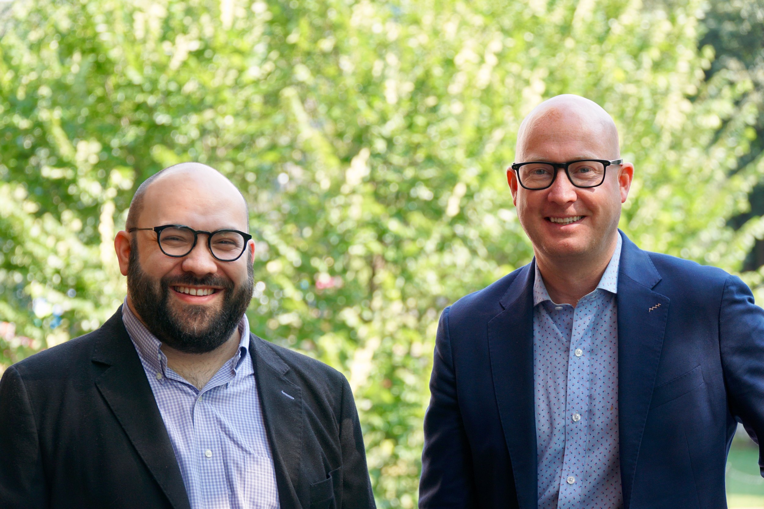 Aaron Wells on the left and Dan Kanninen on the right, smiling outdoors
