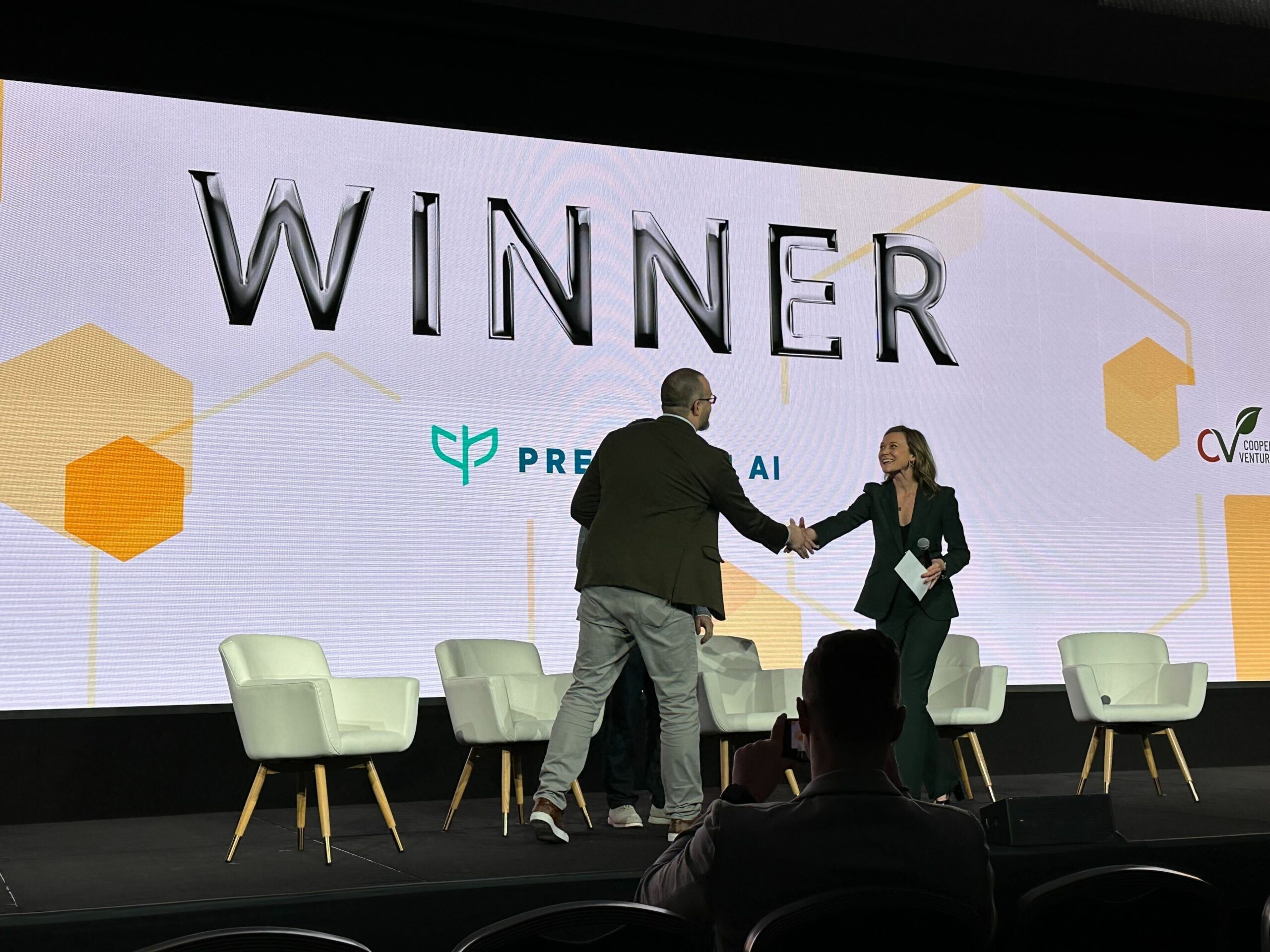 Daniel McCann accepting recognition on stage beneath a Precision AI winner announcement at World Agri-Tech 2023