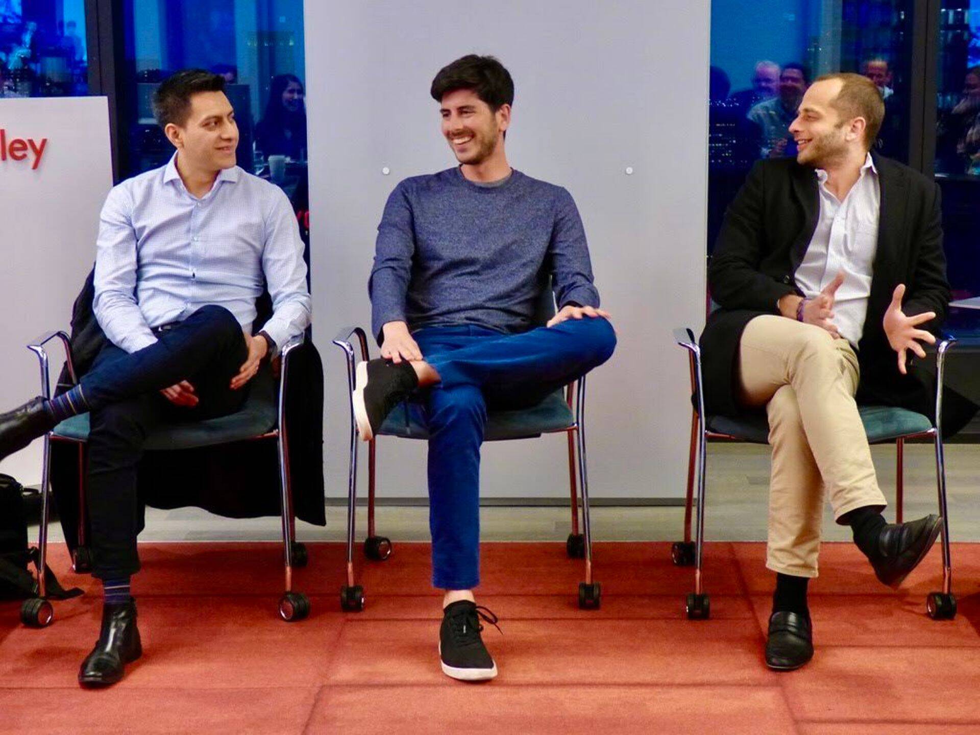 Glia co-founders Carlos Paniagua, Justin DiPietro and Dan Michaeli seated together, with Michaeli speaking on the right