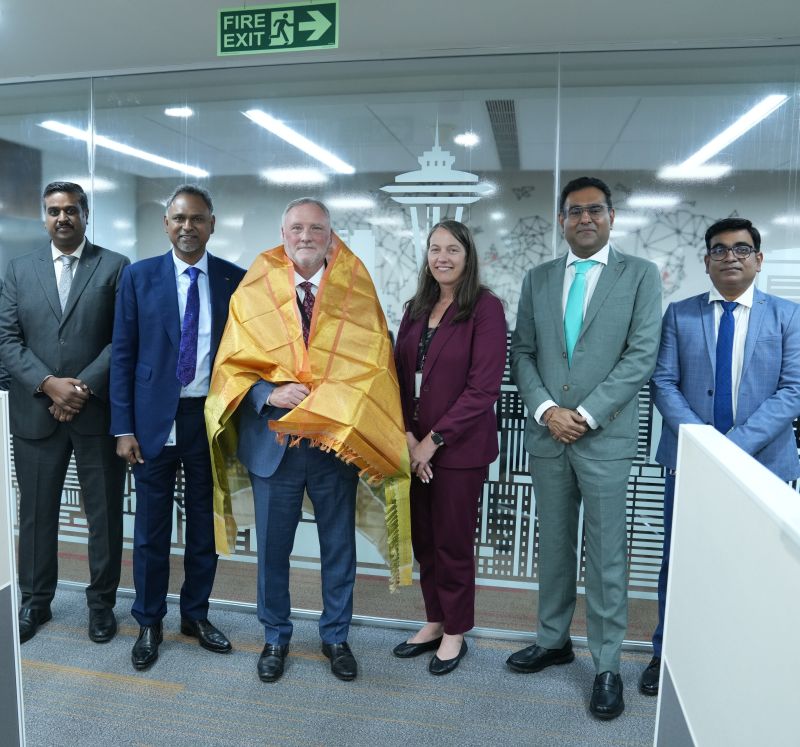 Dan Wall, wearing a gold ceremonial shawl, with Courtney Hawkins and colleagues at Expeditors’ Chennai office.