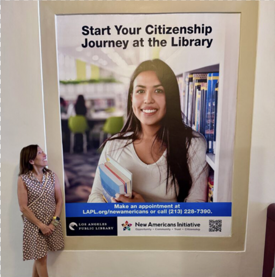 Dana C. Arnett beside the Los Angeles Public Library New Americans Initiative campaign