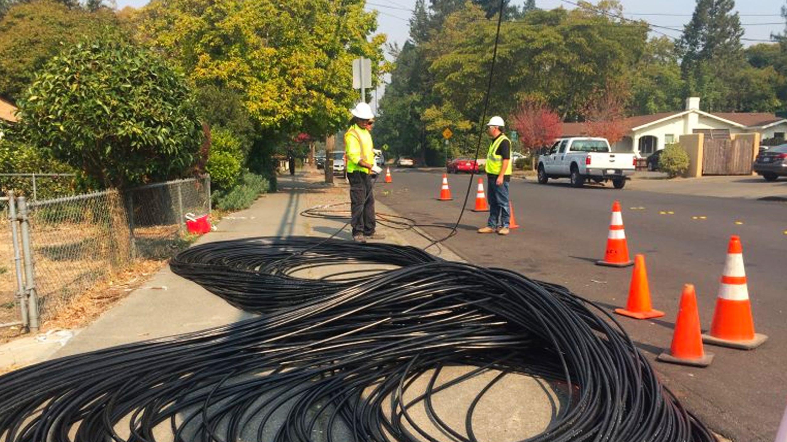 Sonic crews working with fiber cable on a street