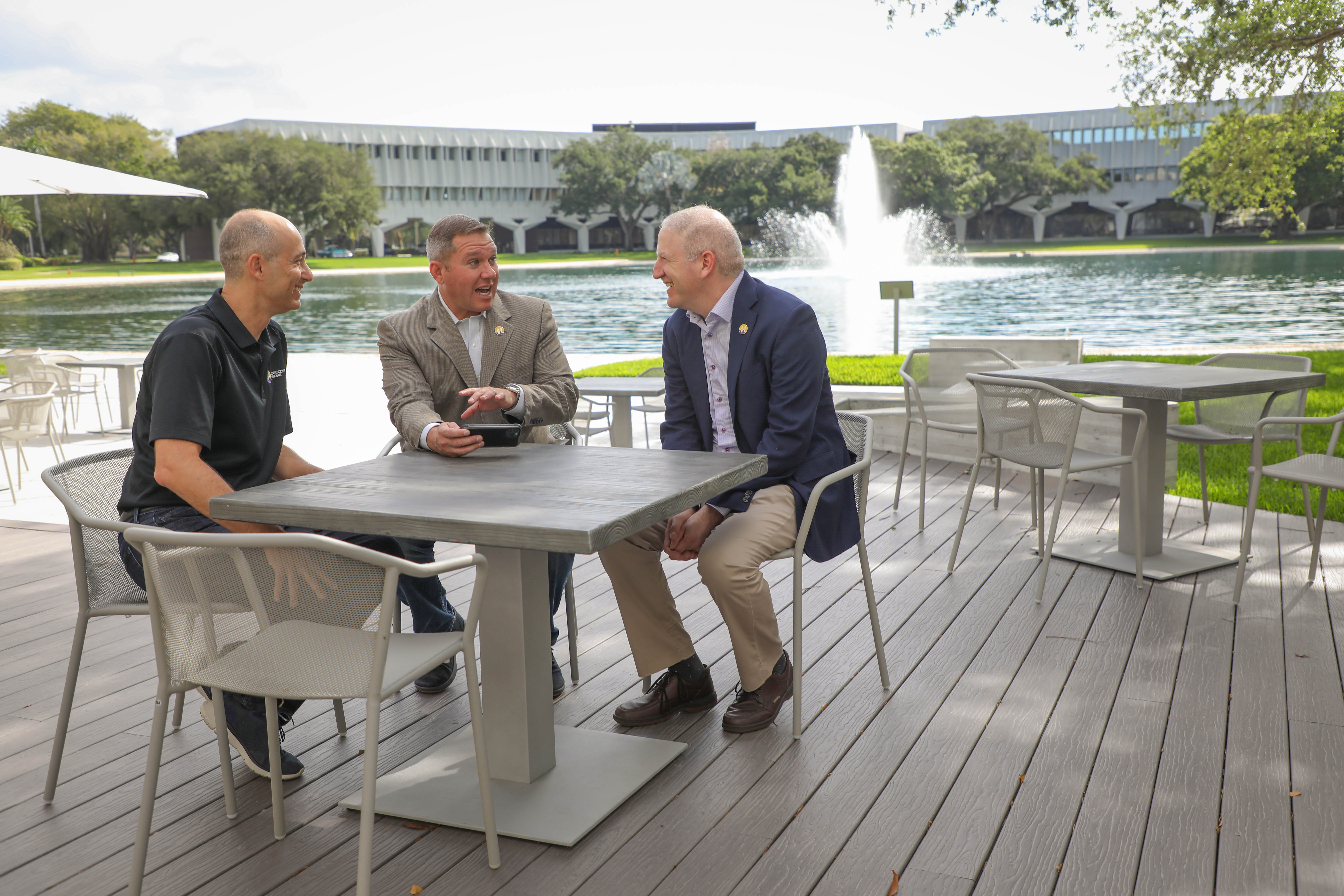 Joe Harpaz, Daniel Cane and Michael Sherling talking around a table at ModMed headquarters