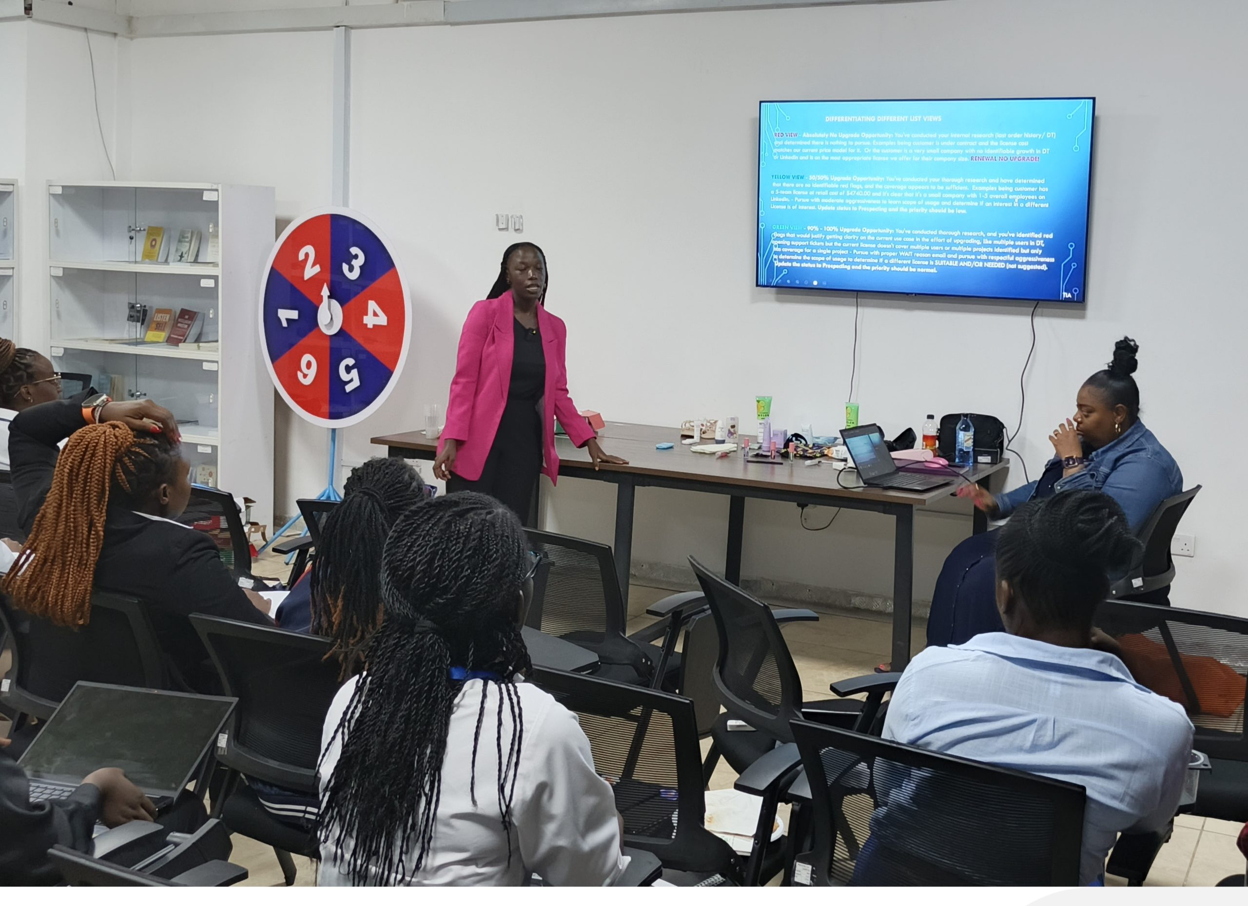 A trainer leads a workshop for Syncfusion employees seated with laptops in Kisumu