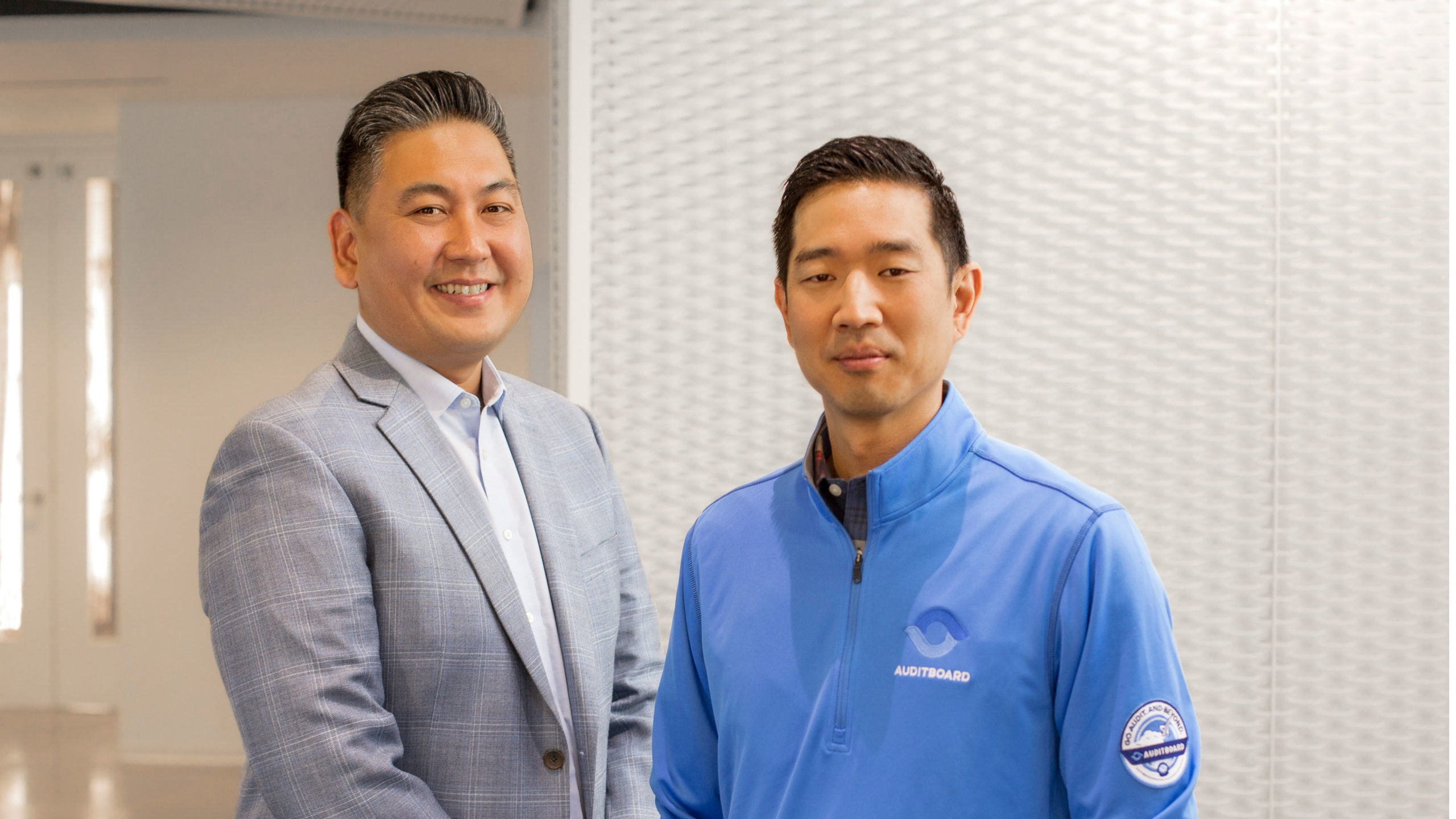 AuditBoard co-founders Jay Lee, left, and Daniel Kim, right, standing together in an office