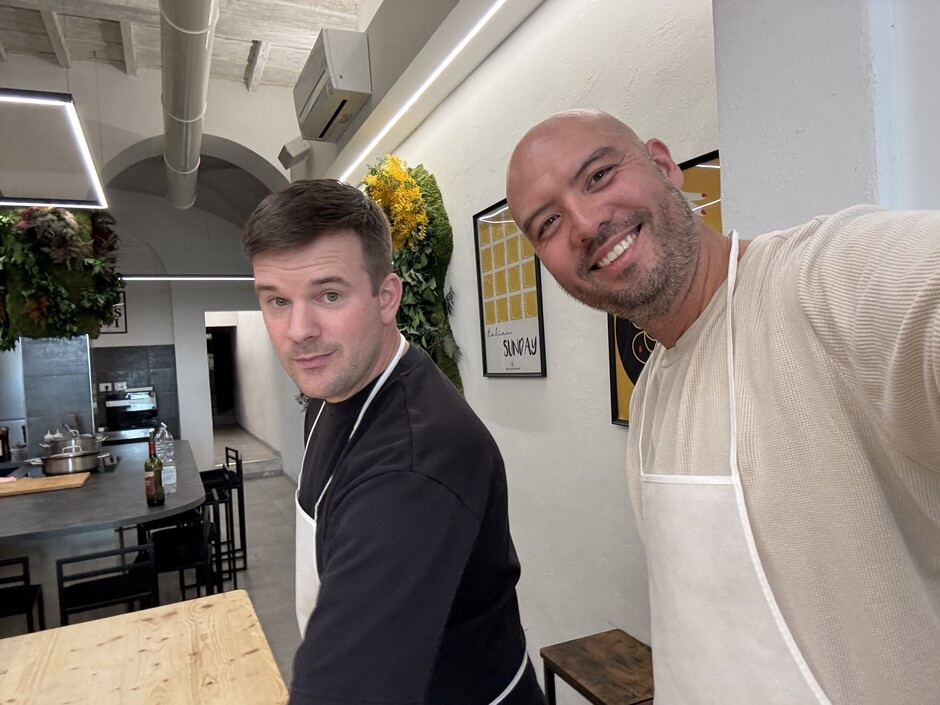 Daniel Pearson, left, and Zachary Kim wearing aprons in a kitchen in Rome