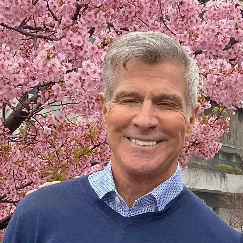 Daniel Pontecorvo standing in front of pink cherry blossoms