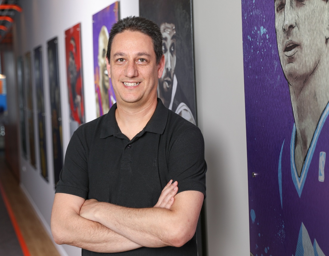 Daniel Shichman in a WSC Sports office corridor lined with basketball player artwork