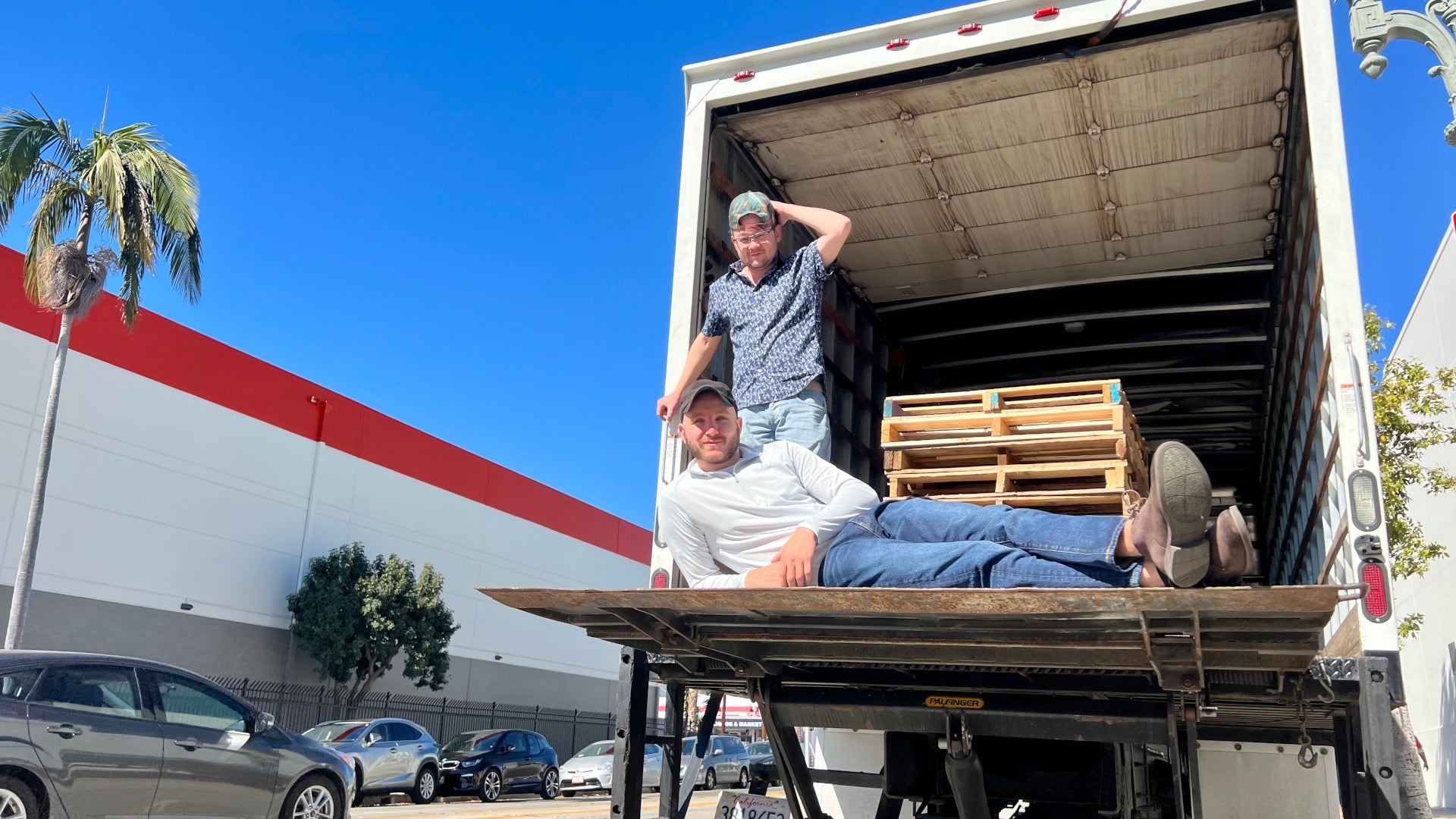 Warp co-founders Daniel Sokolovsky and Troy Lester posing in the open rear of a delivery truck