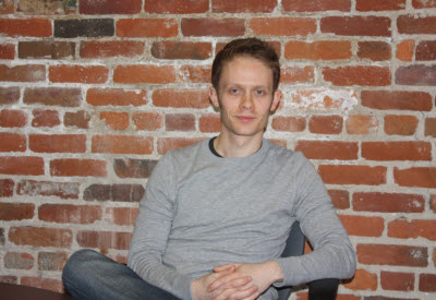 Daniel Terry seated in front of a brick wall in a photograph accompanying his 2011 interview
