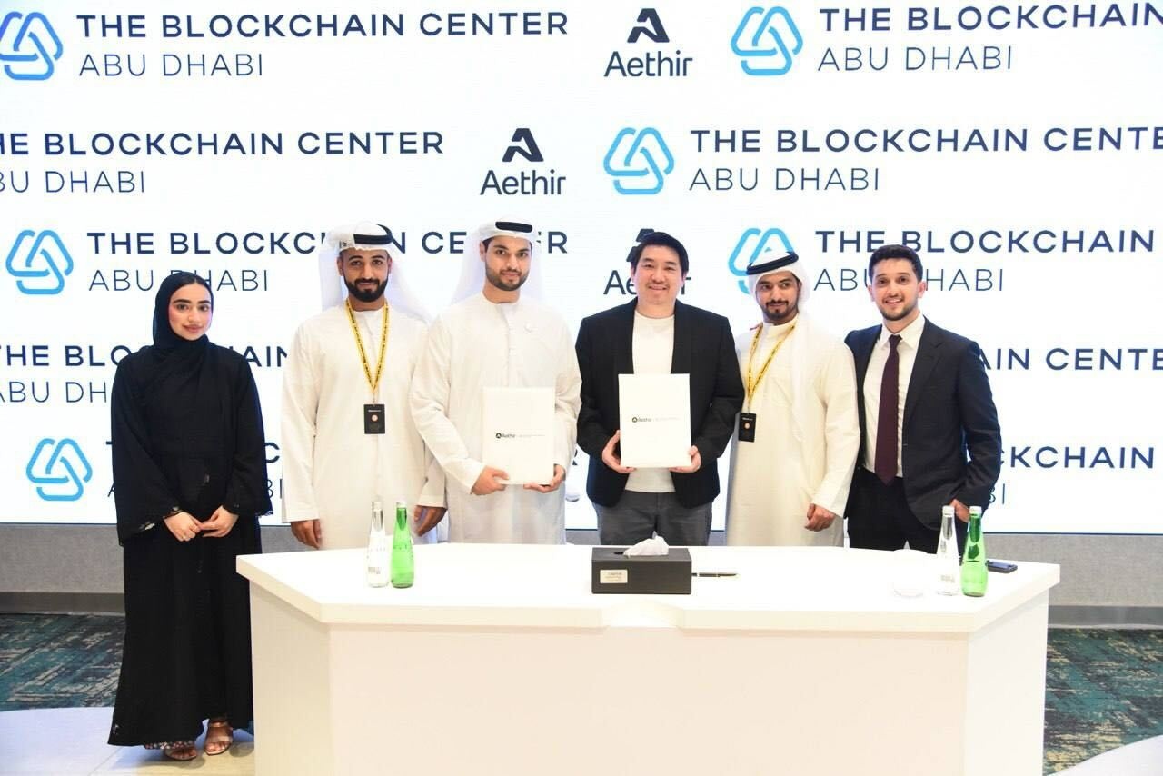 Daniel Wang, fourth from left, holding an agreement alongside representatives at The Blockchain Center Abu Dhabi
