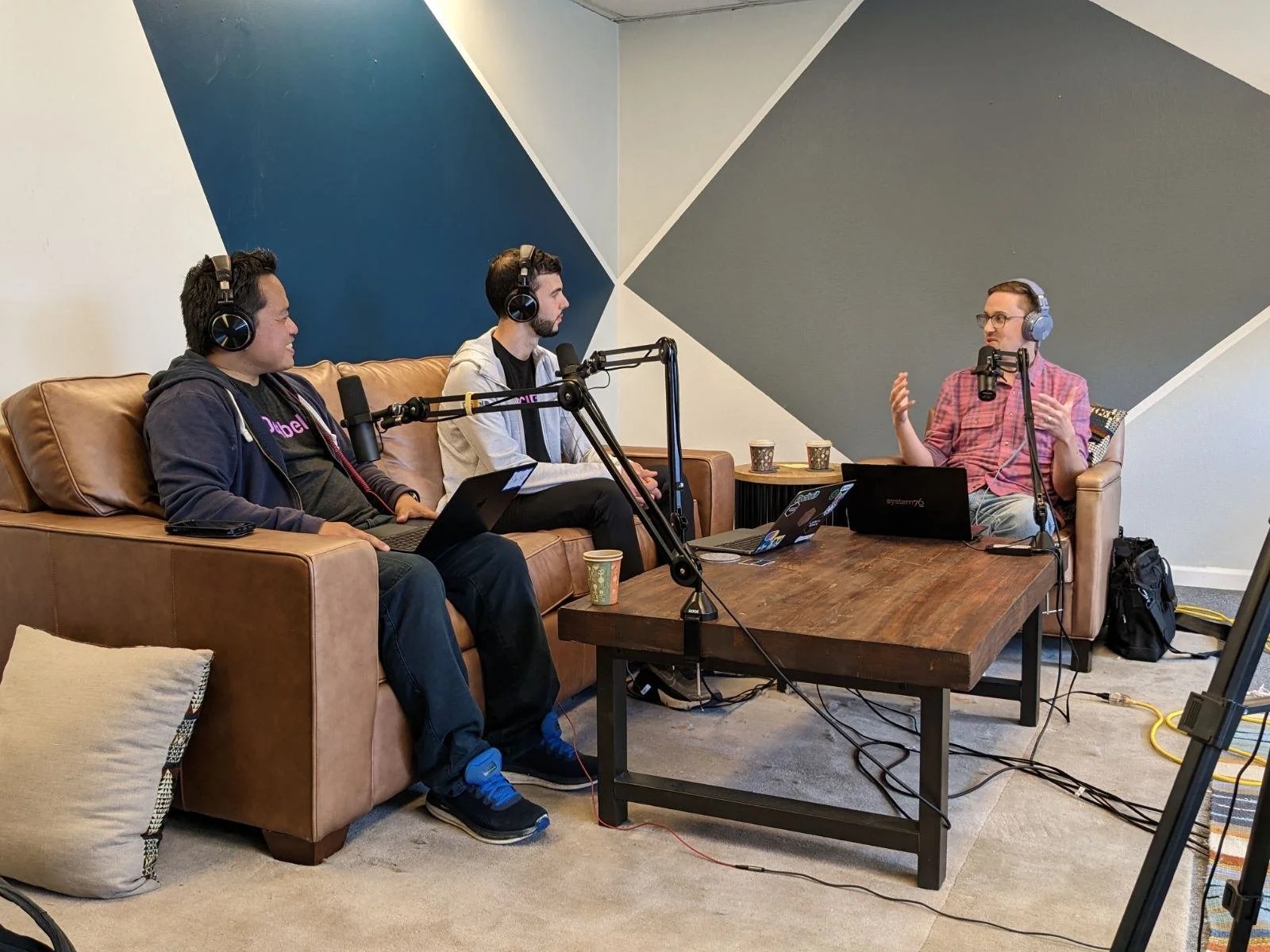 Daniel Whitenack, at right, talking with two participants around microphones and laptops in a recording room.