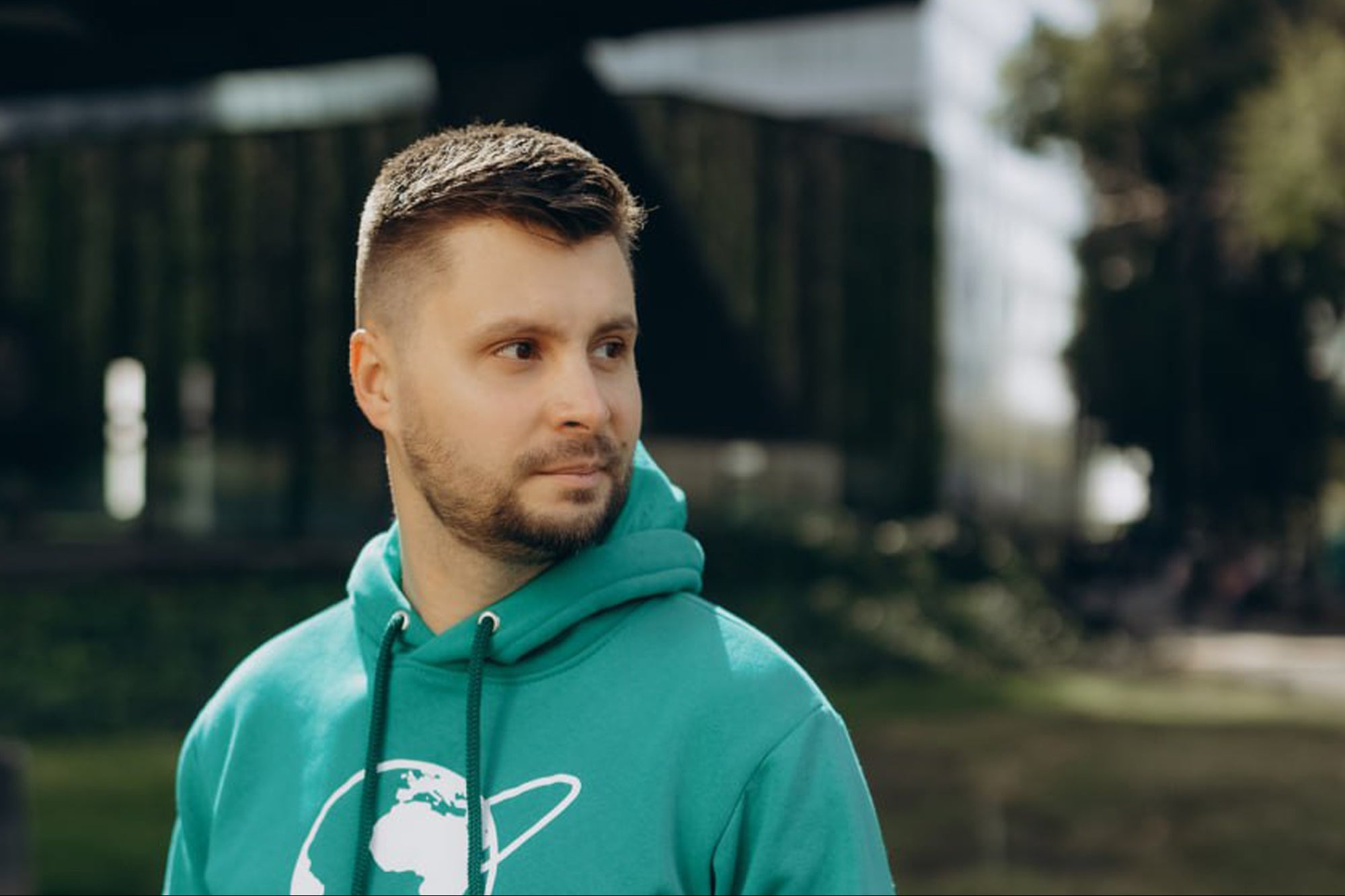 Danil Kislinskiy outdoors wearing a green Go Global World hoodie