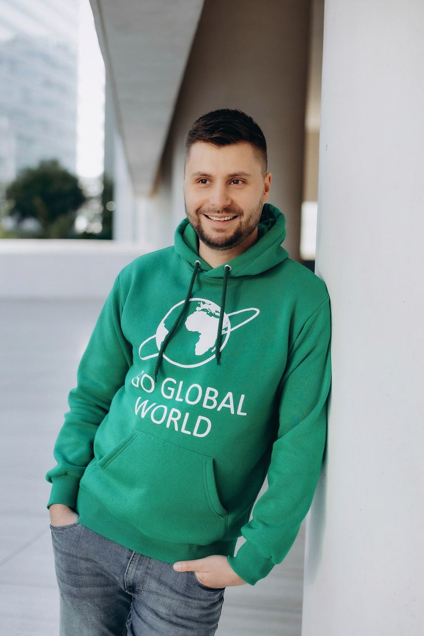 Danil Kislinskiy smiling in a green Go Global World sweatshirt