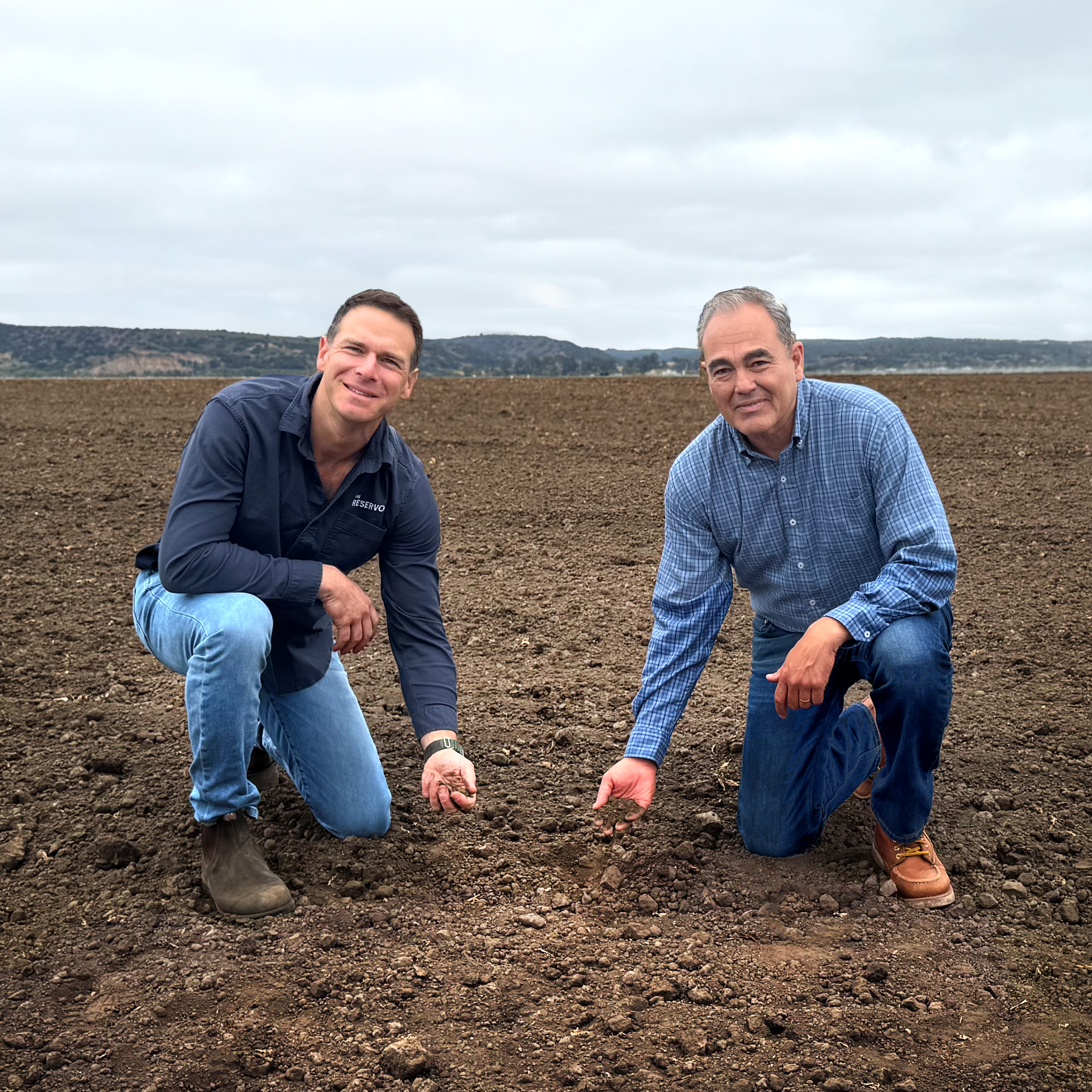 Danny Bernstein and Hank Guerrero kneeling in a field at Reservoir Farms