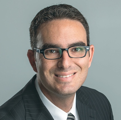 Danny Rivera wearing glasses and a suit in his 2015 Meineke-era photograph