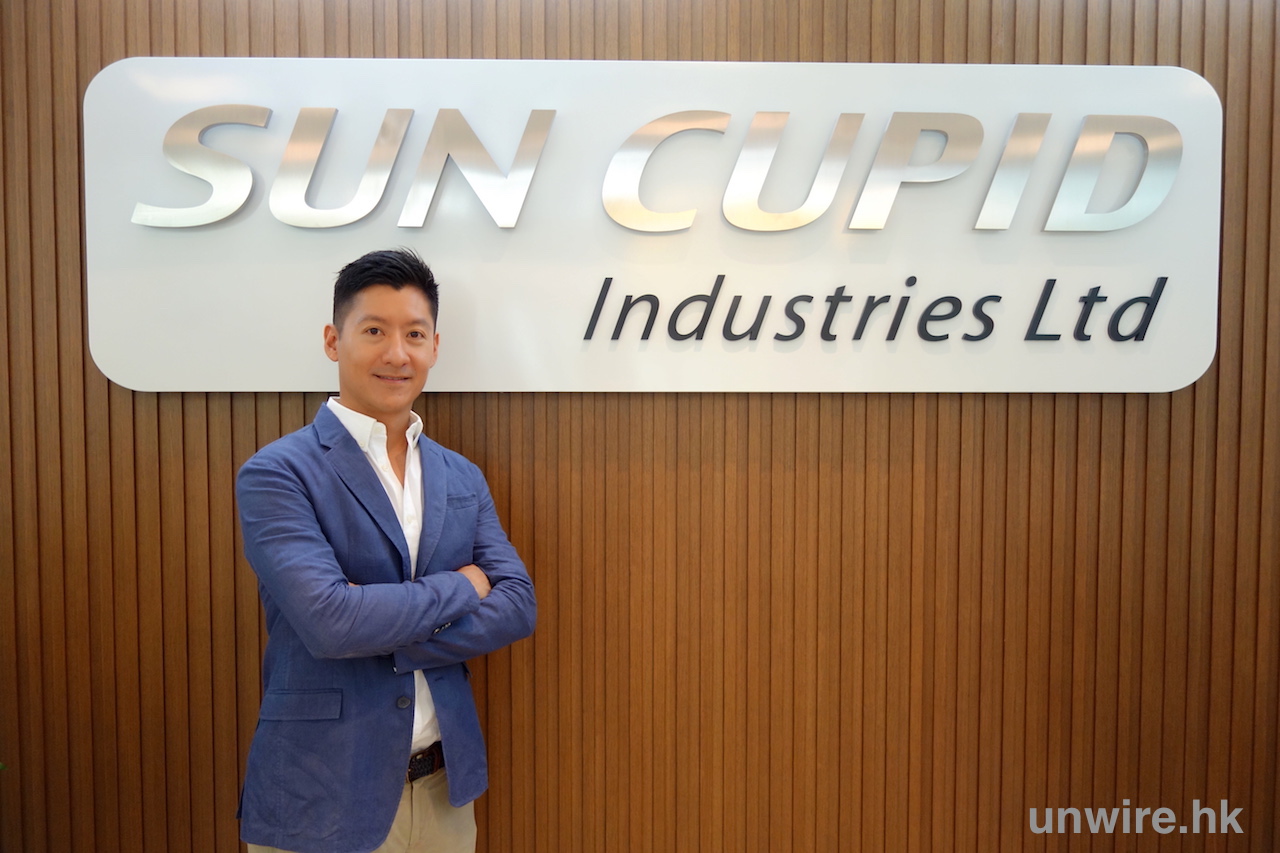 Danny Sit standing beside the Sun Cupid Industries sign in 2015