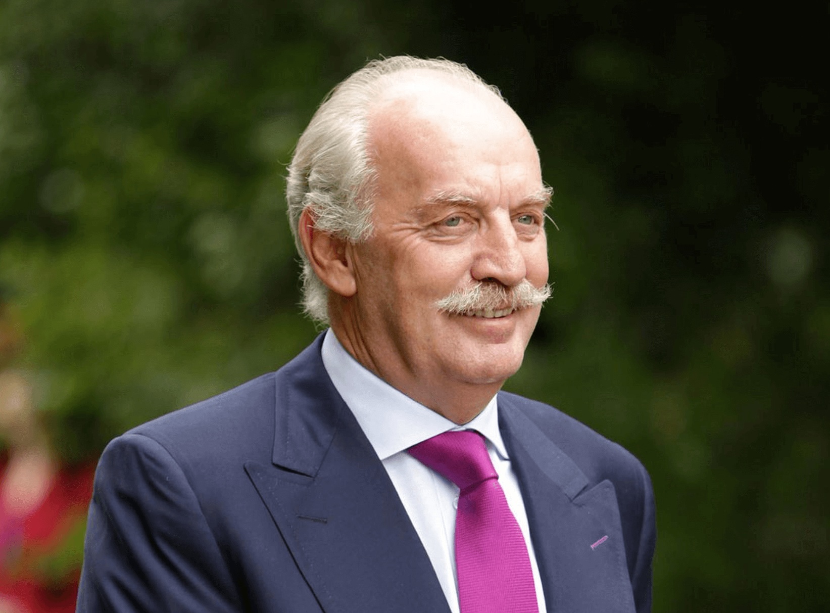 Daon founder Dermot Desmond outdoors in a suit