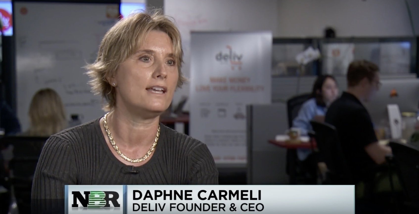 Daphne Carmeli being interviewed in the Deliv office, with colleagues working behind her.