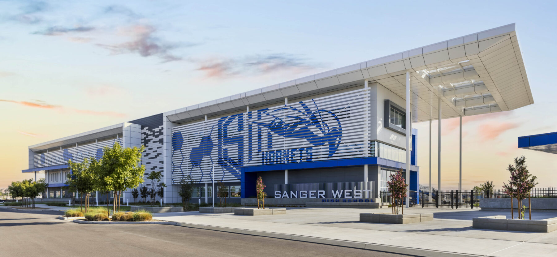 The exterior of Sanger West High School, with a patterned shade screen and broad white canopy