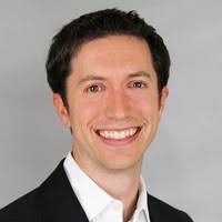 An archival photograph of Darin Buxbaum wearing a dark jacket and white shirt