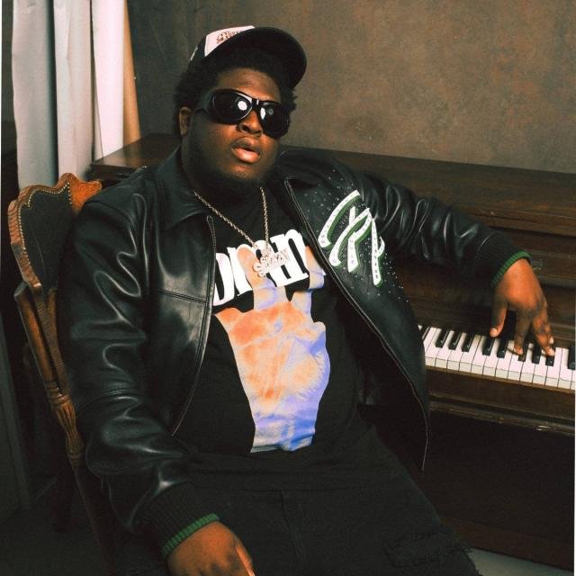 Cash Cobain seated beside a piano