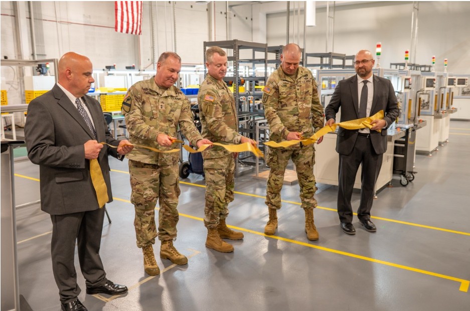 Army leaders and partners cutting a ribbon at Tobyhanna’s motor assembly lines
