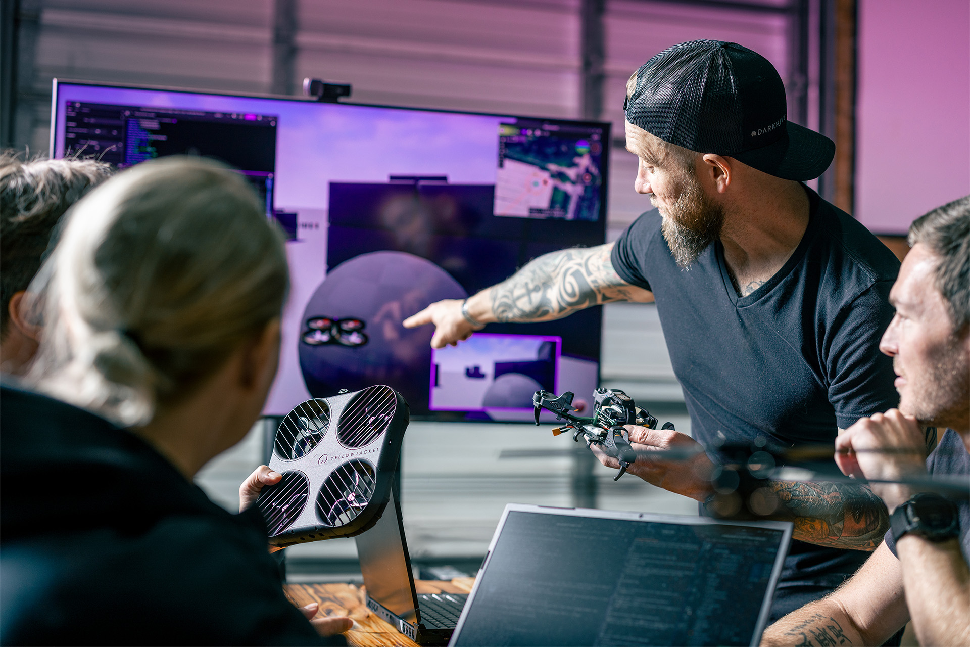 Darkhive development team working around a desk with aircraft hardware and software displays