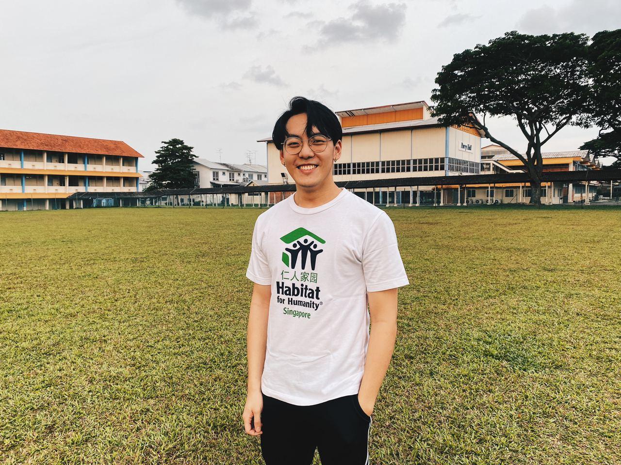 Darren Lee wearing a Habitat for Humanity Singapore T-shirt on a field