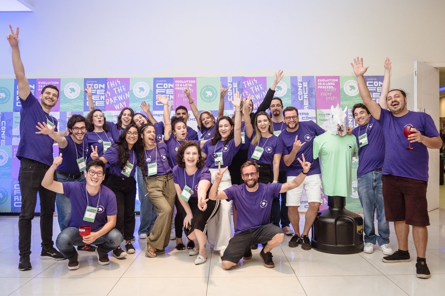 Darwin Conference 2024 group wearing purple shirts and celebrating together