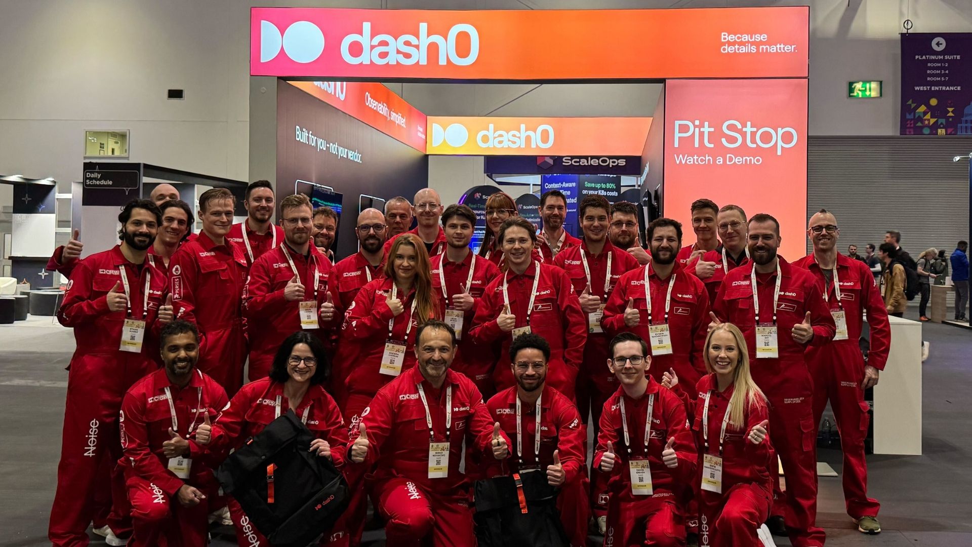 Dash0 team in red coveralls at a conference booth