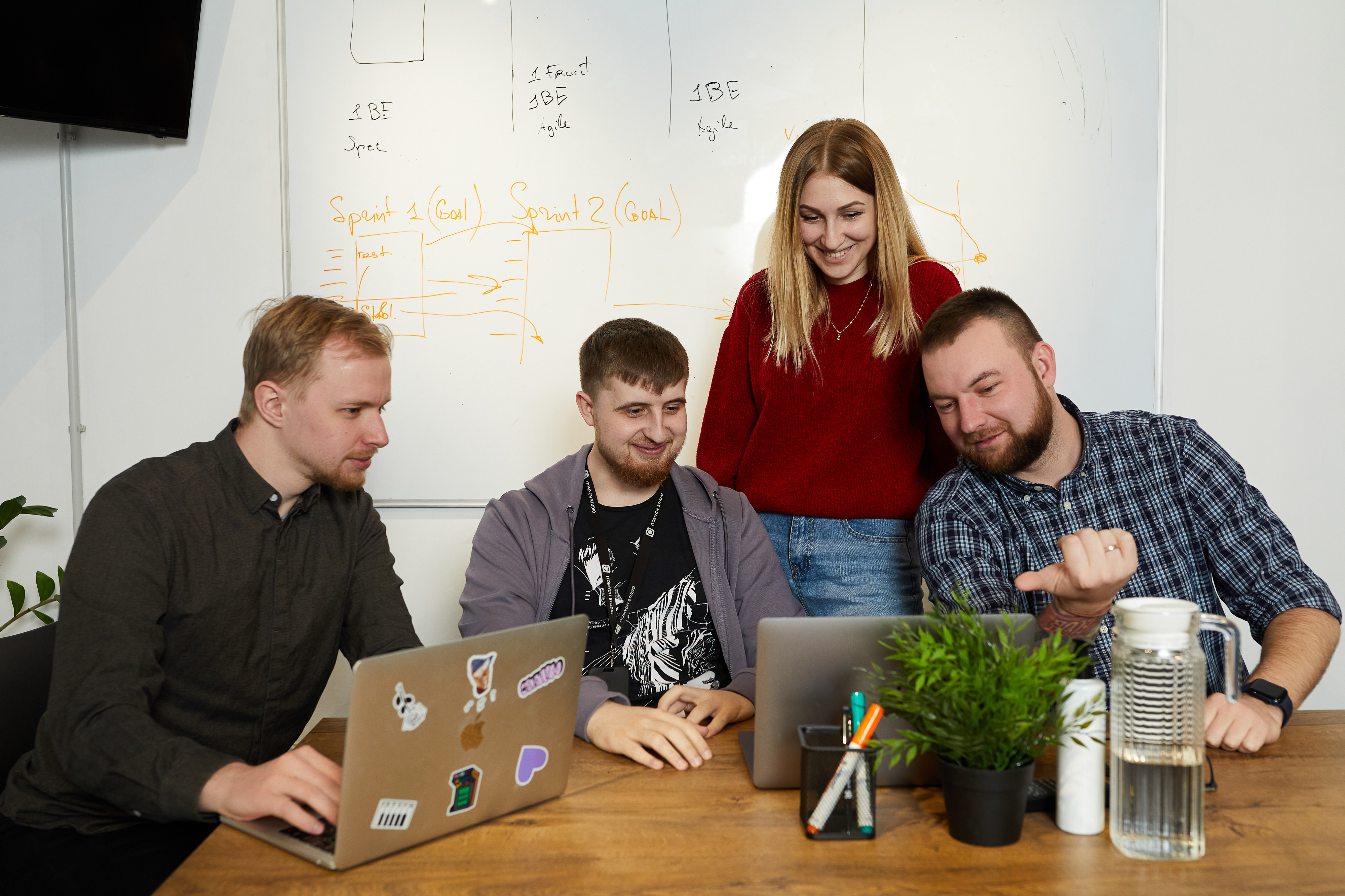 DashDevs colleagues gathered around laptops at an office table