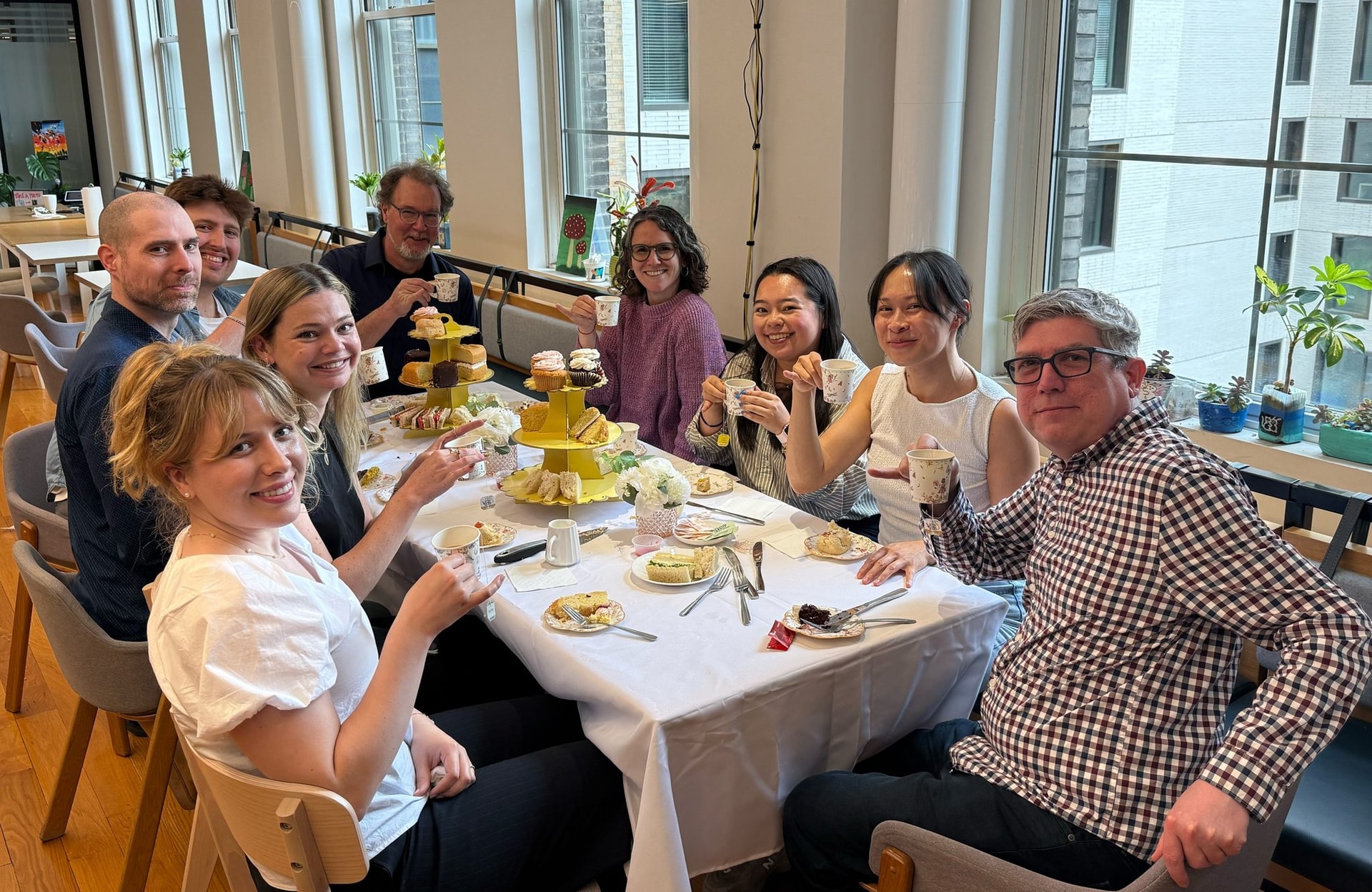 Dashlane colleagues sharing tea and cakes around a table in the New York office