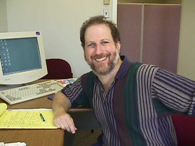 Datacor founder Dave Rosenthal seated at his desk beside a computer