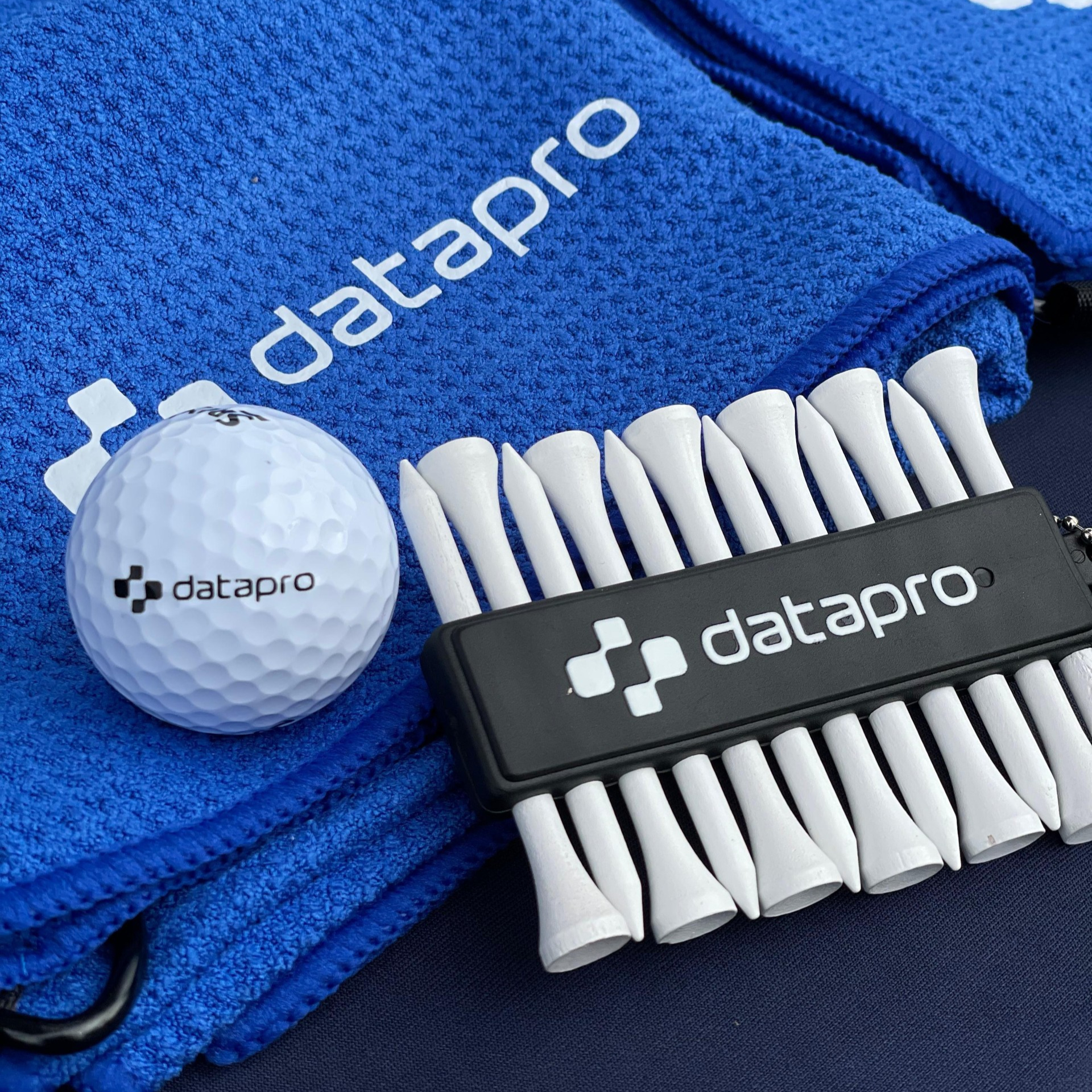 Datapro-branded golf ball, tees, and blue towel at the banking golf event