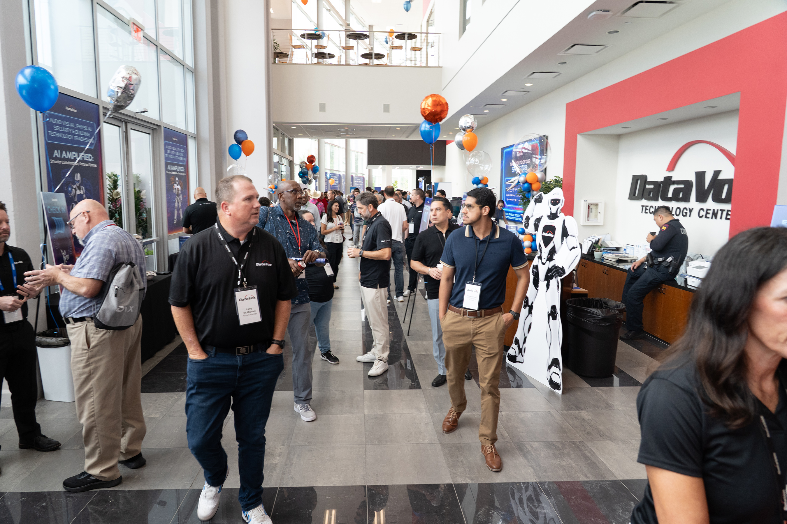 Attendees and a robot-shaped display in the lobby of DataVox’s Technology Center during its 2026 tradeshow