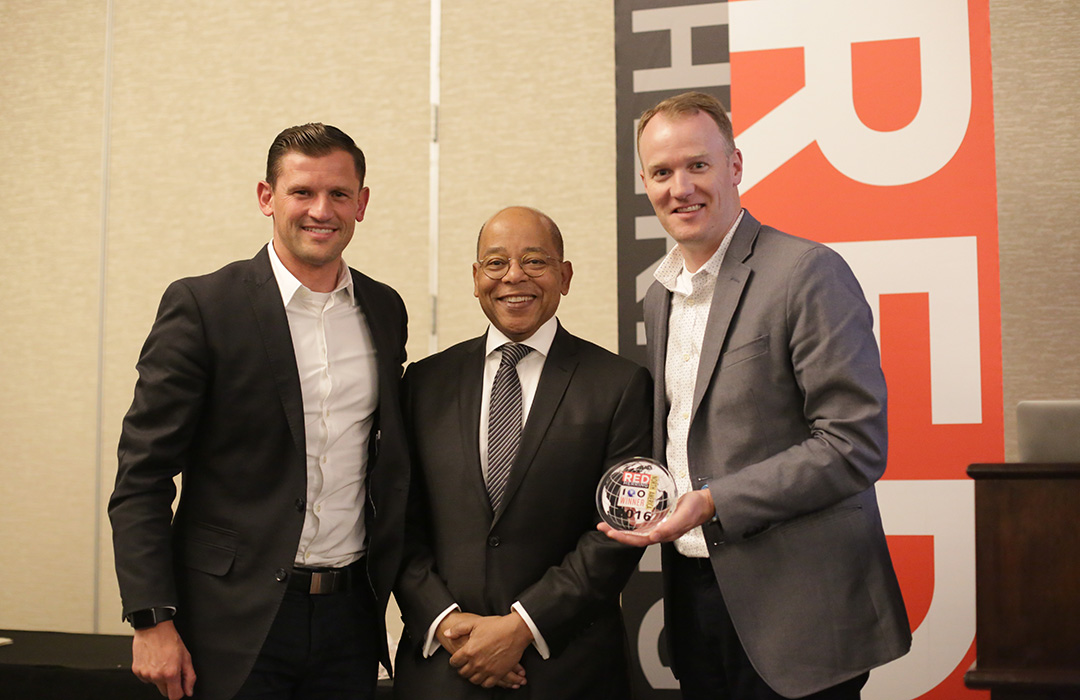 Dave Blake, at right, holding ClientSuccess’s Red Herring award alongside two other attendees