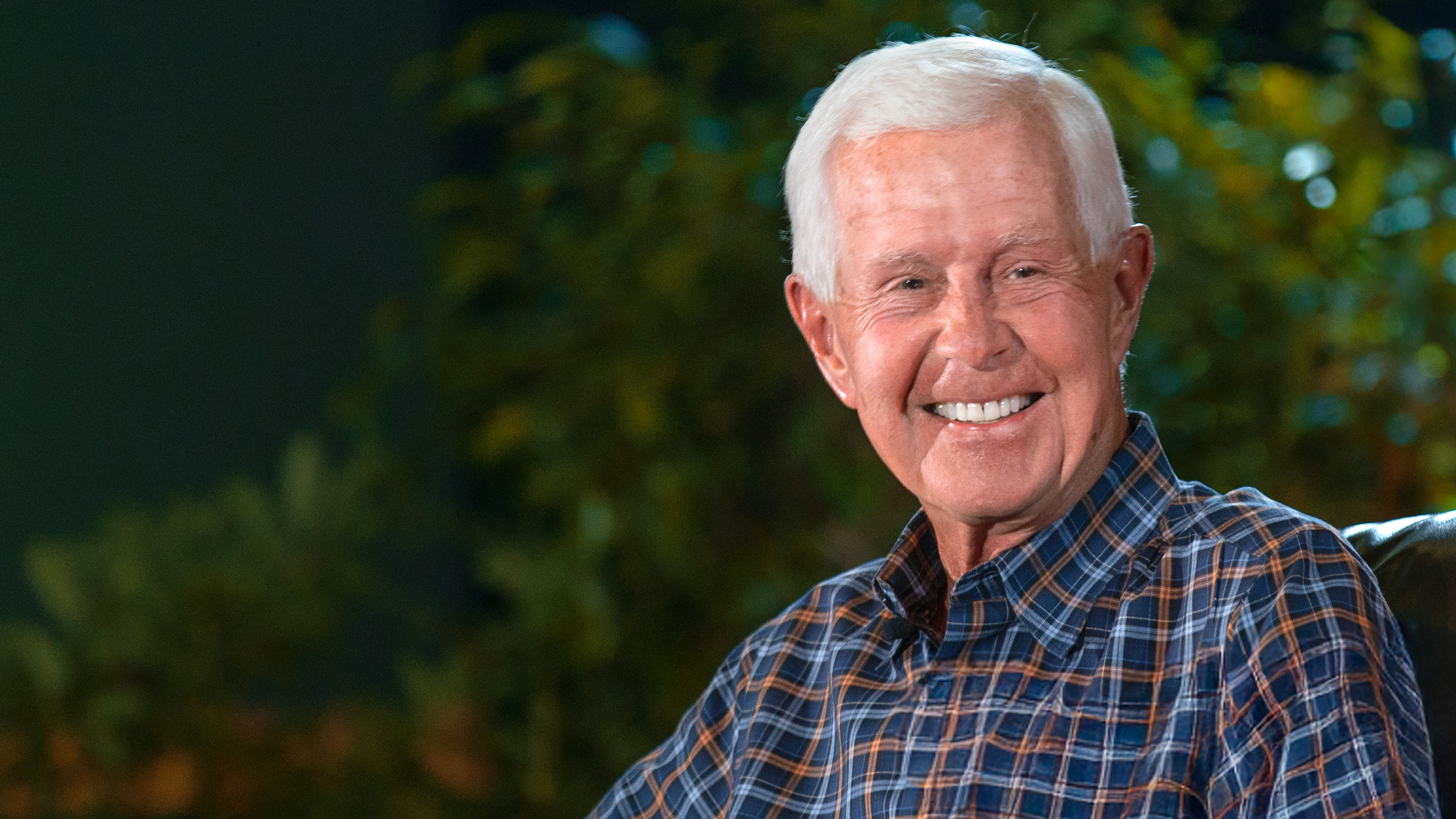 Dave Duffield smiling outdoors in a blue checked shirt
